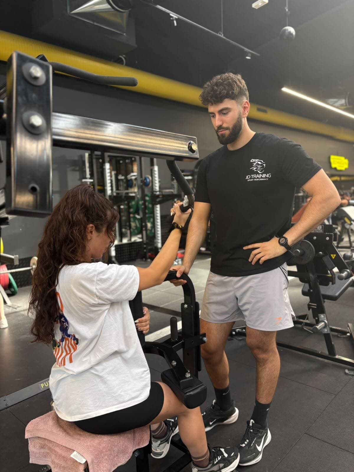 Jules Dupost encadre une cliente sur une machine, en salle